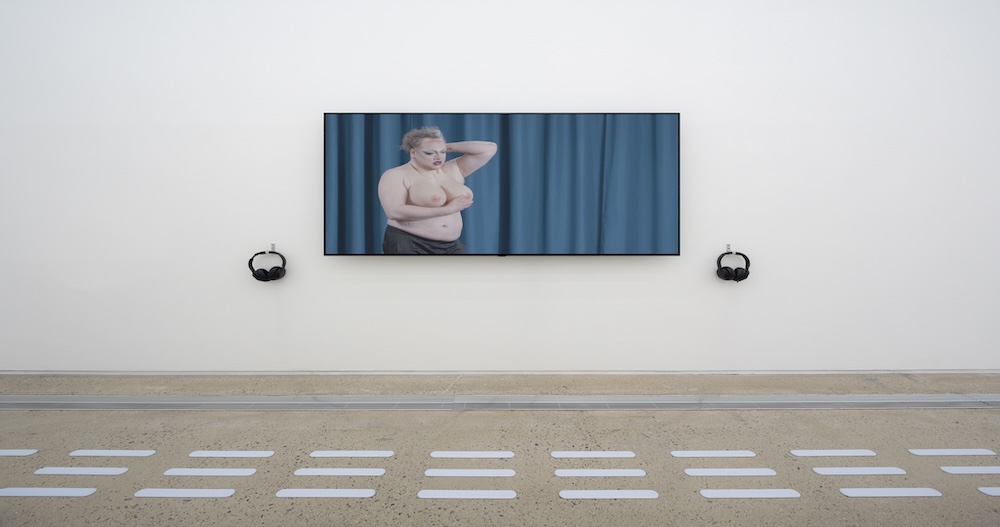 작가, 조영주. 작품명, 커튼 속 살. 부문, 뉴미디어. 제작년도, 2025년. 매체 및 기법, 단채널 영상, 컬러, 사운드. 러닝타임, 15분. 국립현대미술관 제작지원. 영상 스틸. 요가복을 입은 여성들이 허리를 굽히고 골반 운동을 하고 있다.